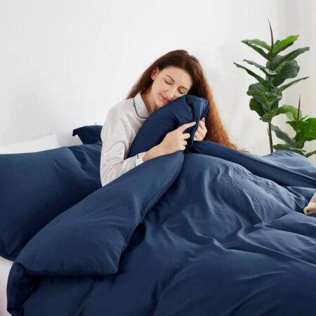 a white woman holding a navy blue comforter